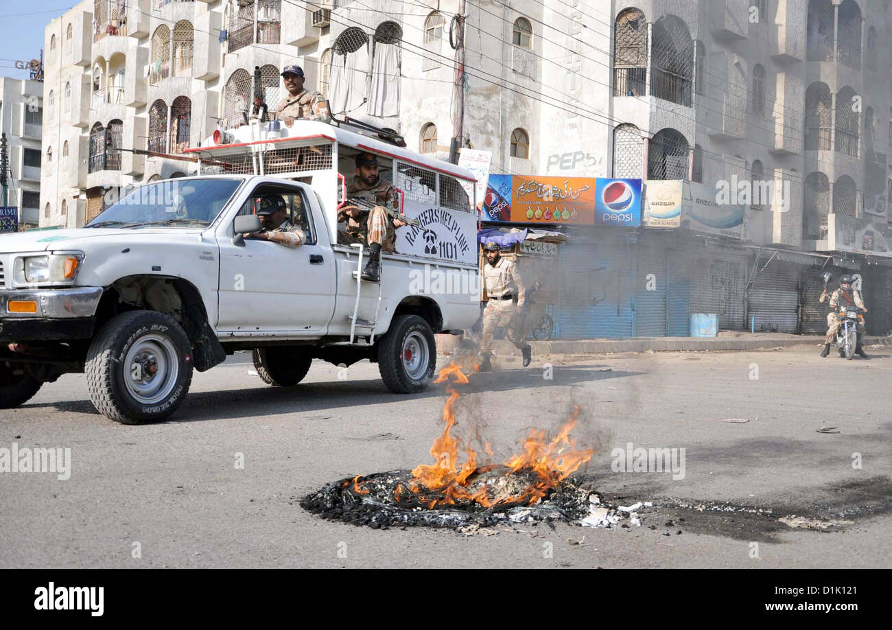 KARACHI, PAKISTAN, DEC 26: Rangers officials stand alert near burning tyres after disperse  protesters during strike called by Ahle Sunnat Wal Jamat (Defunct Sipah-e-Sahaba) against an  assassination attack on their leader Aurangzeb Farooqi convoy and killing of his seven gunmen  and driver, at Nagan Chowrangi area in Karachi on Wednesday, December 26, 2012.  (S.Imran Ali/PPI Images). Stock Photo