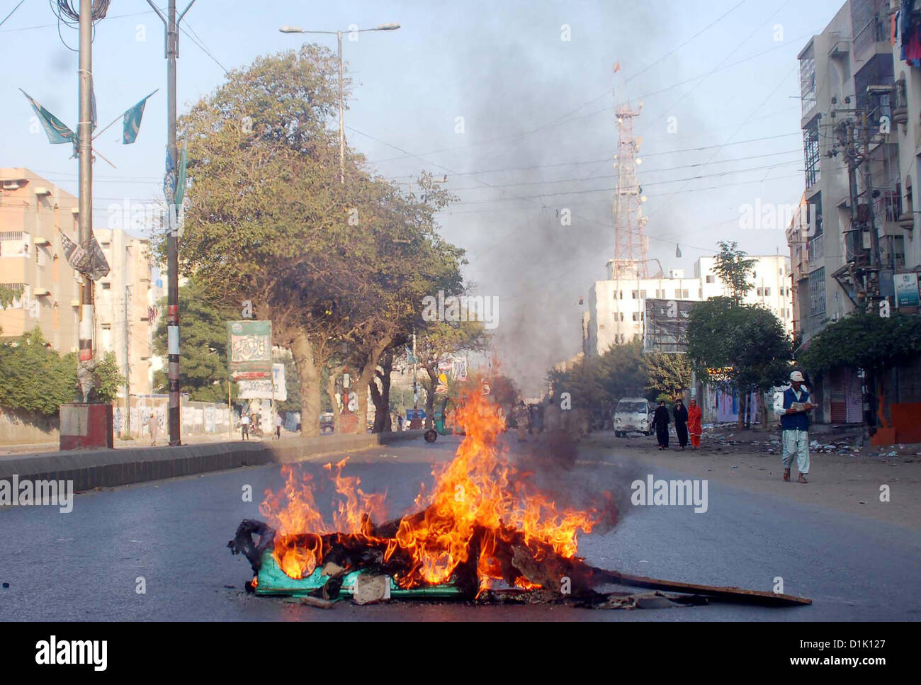 View of Fire lighten set ablaze by angry protesters during  strike called by Ahle Sunnat Wal Jamat (Defunct Sipah-e-Sahaba) against an assassination attack  on their leader Aurangzeb Farooqi convoy and killing of his seven gunmen and driver, at Patel  Para area in Karachi on Wednesday, December 26, 2012. Stock Photo
