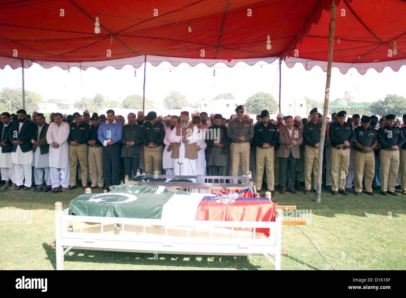 People of funeral prayer of the police officials, who killed in  an assassination attack on Ahle Sunnat Wal Jamat (Defunct Sipah-e-Sahaba) leader Aurangzeb  Farooqi convoy, at Police Lines Garden Headquarter in Karachi on Wednesday, December 26,  2012. Stock Photo
