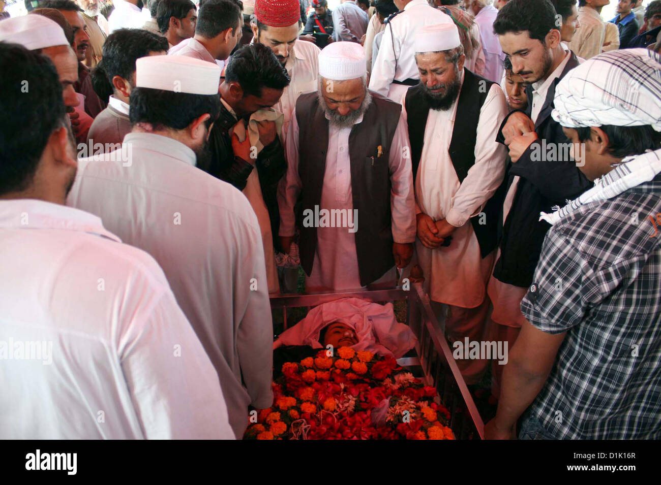 People watching their loved ones police official, who killed  in an assassination attack on Ahle Sunnat Wal Jamat (Defunct Sipah-e-Sahaba) leader  Aurangzeb Farooqi convoy, after funeral prayer at Police Lines Garden Headquarter in Karachi  on Wednesday, December 26, 2012. Stock Photo