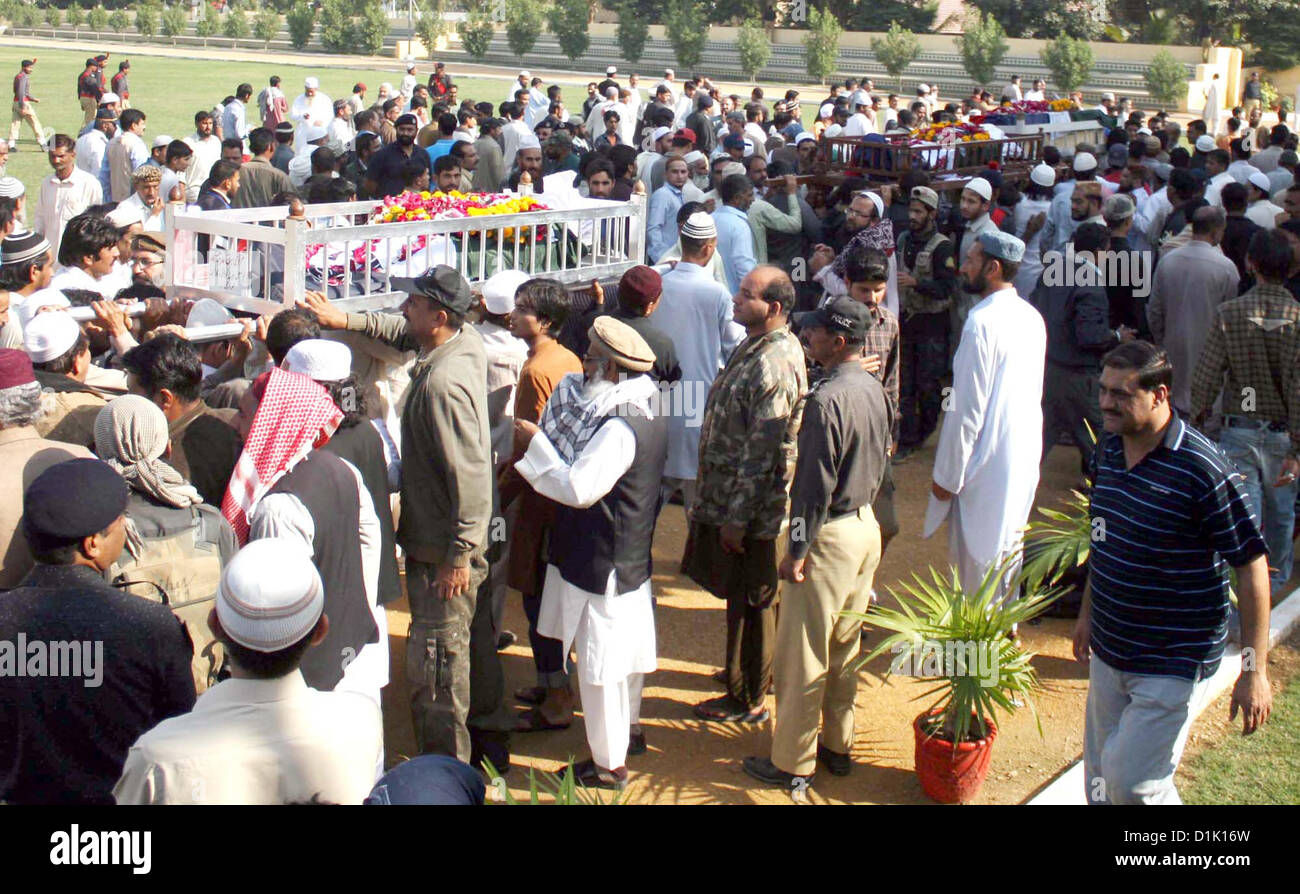 People carry coffin of police officials, who killed in an  assassination attack on Ahle Sunnat Wal Jamat (Defunct Sipah-e-Sahaba) leader Aurangzeb  Farooqi convoy, to laid them rest after their funeral prayer at Police Lines Garden Headquarter  in Karachi on Wednesday, December 26, 2012 Stock Photo