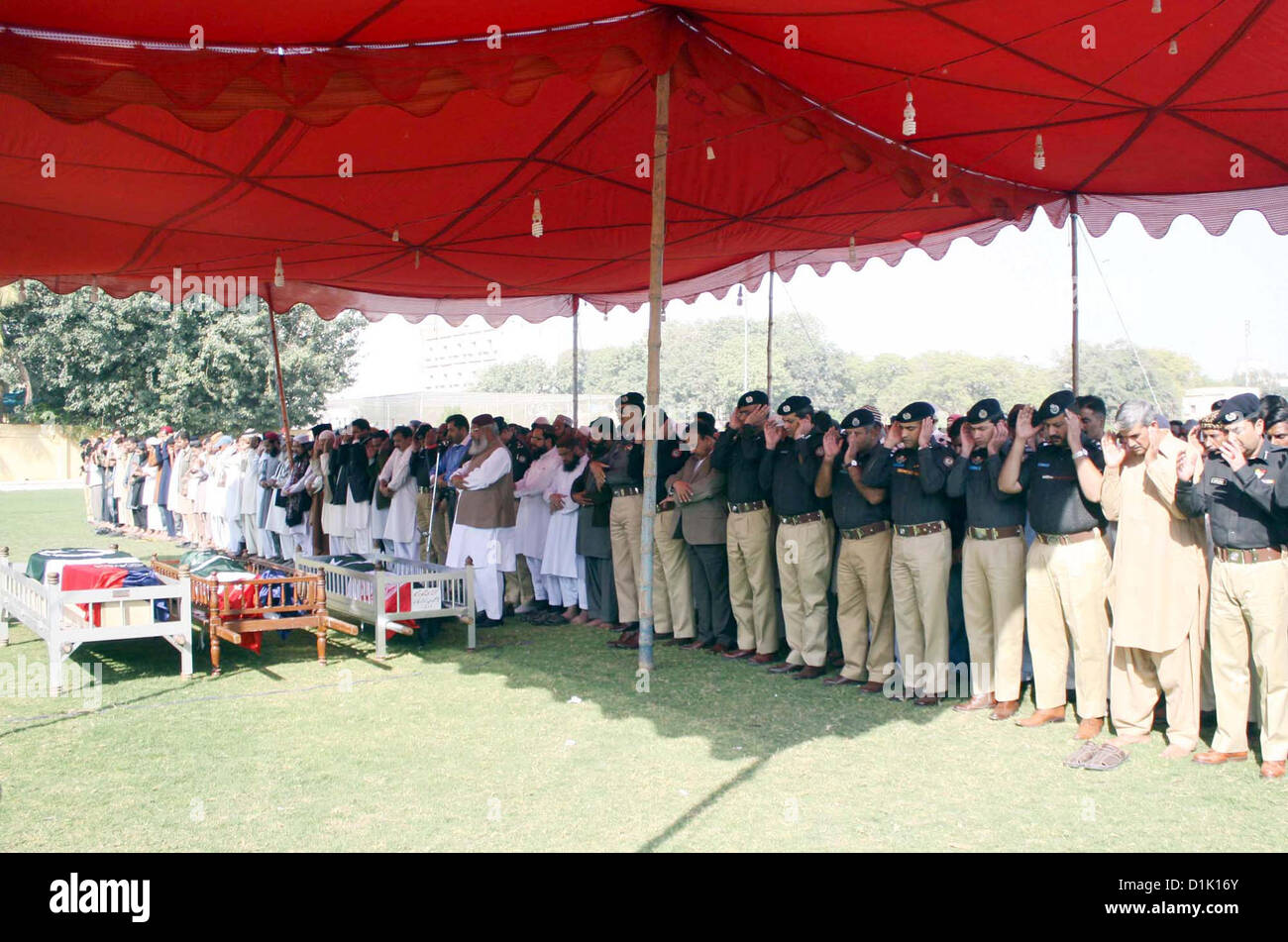 People of funeral prayer of the police officials, who killed in  an assassination attack on Ahle Sunnat Wal Jamat (Defunct Sipah-e-Sahaba) leader Aurangzeb  Farooqi convoy, at Police Lines Garden Headquarter in Karachi on Wednesday, December 26,  2012. Stock Photo