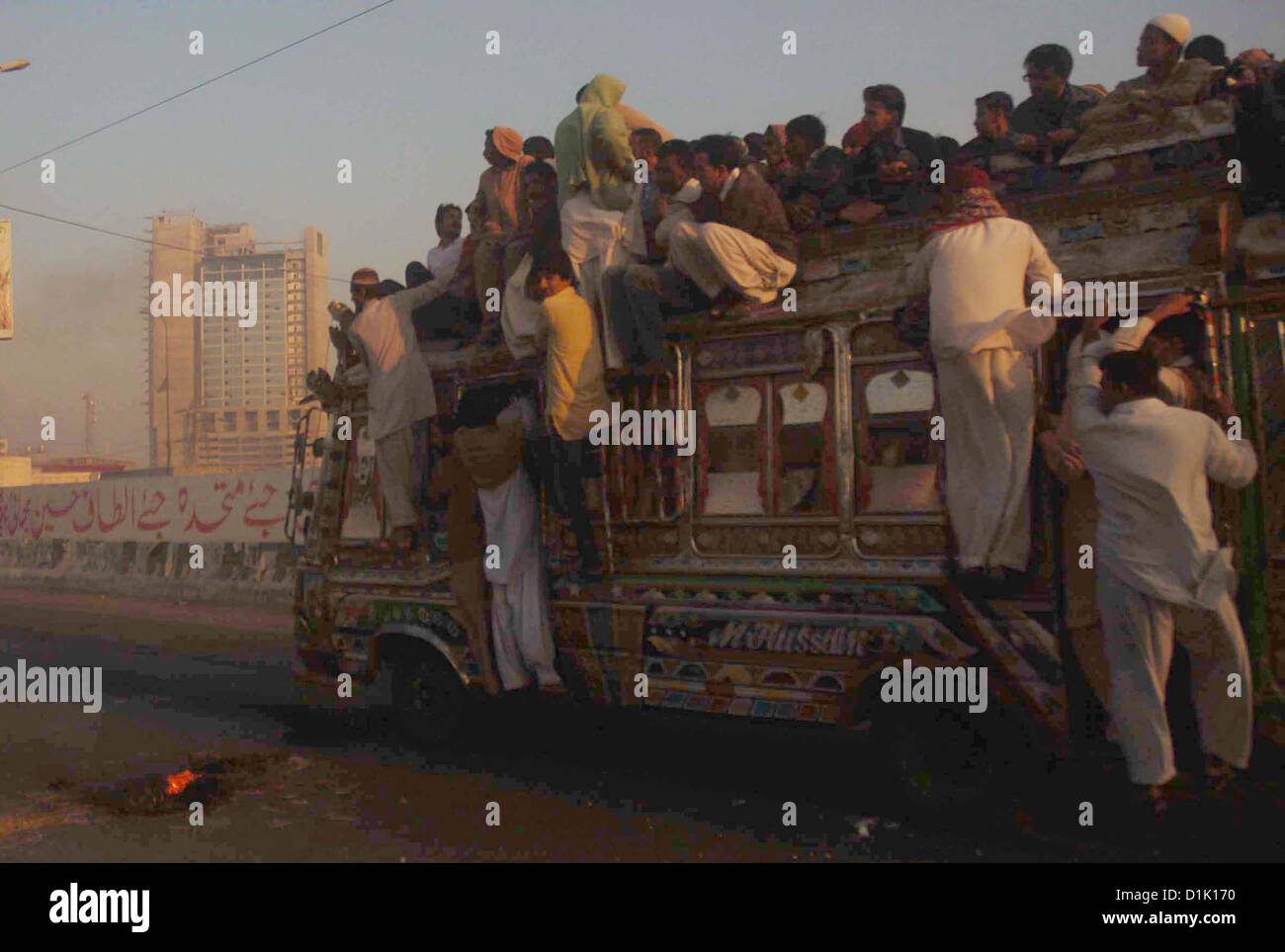 Passengers traveling on an overloaded bus as the shortage  of transportation is being observed in city during strike called by Ahle Sunnat Wal Jamat  (Defunct Sipah-e-Sahaba) against an assassination attack on their leader Aurangzeb Farooqi  convoy and killing of his seven gunmen and driver, at Qayyumabad Road in Karachi on  Wednesday, December 26, 2012. Stock Photo