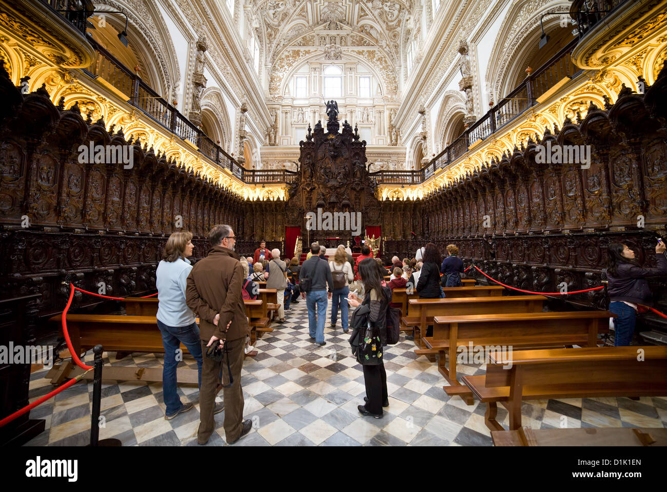 Mahogany choir stalls and group of tourists on a tour inside the Mezquita Cathedral in Cordoba, Andalucia, Spain. Stock Photo