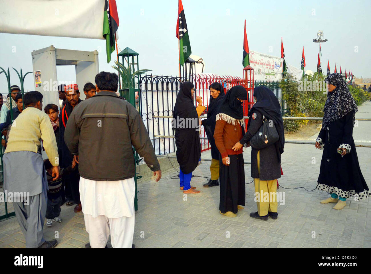 Security officials search people who come to  attend 5th Death Anniversary of Benazir Bhutto, in Garhi Khuda Bux on Wednesday, December  26, 2012. Stock Photo