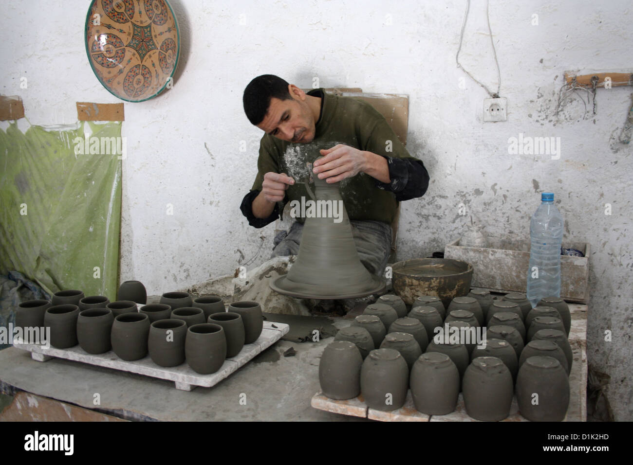 A workman crafts a pot at a pottery in Fez, Morocco Stock Photo
