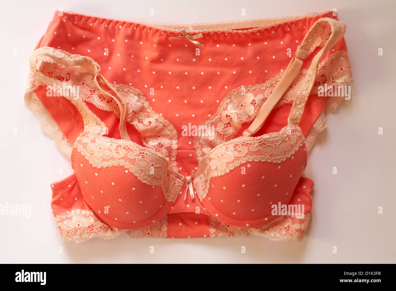matching sexy polka dot peach coloured with white lace edged underwear set  - bra and knickers set on white background Stock Photo - Alamy