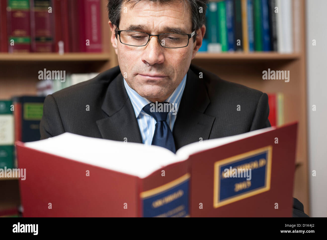Environmental corporate portrait of solicitor, lawyer, attorney reading Archbold 2013 law book in his office. Stock Photo