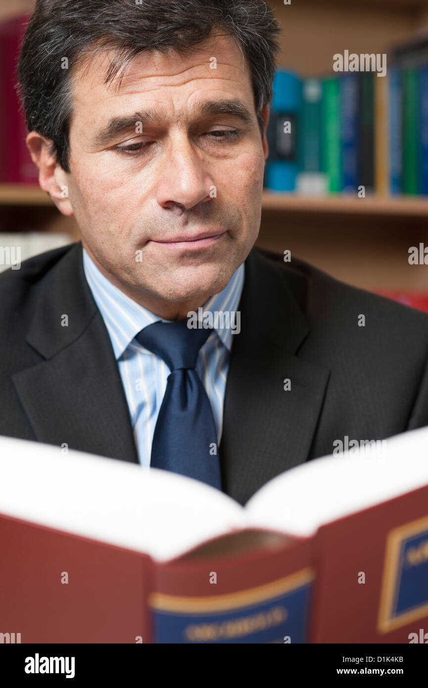 Environmental corporate portrait of solicitor, lawyer, attorney reading Archbold 2013 law book in his office. Stock Photo