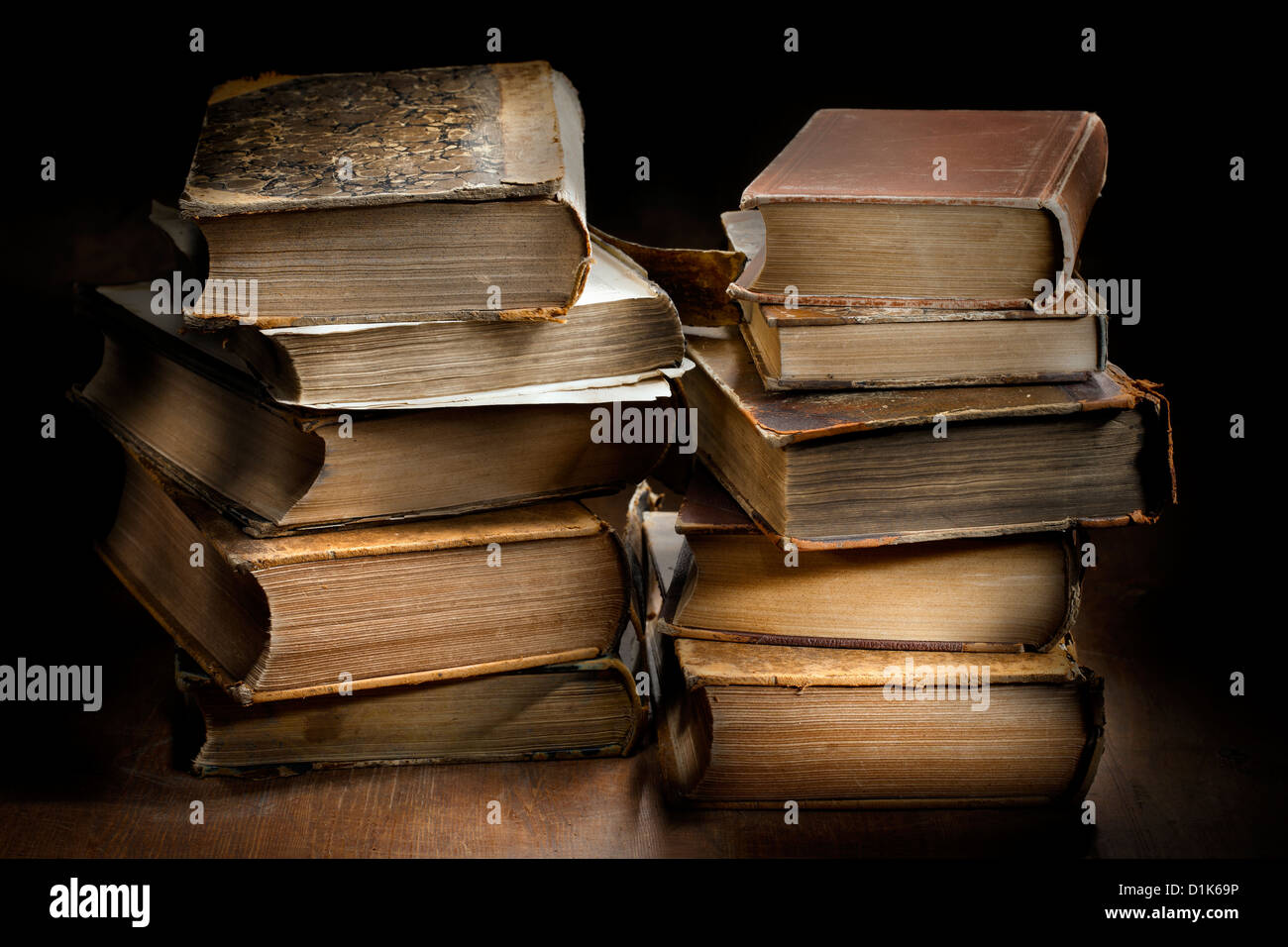 Dark and moody photograph od two stacks of old worn antique books. Stock Photo