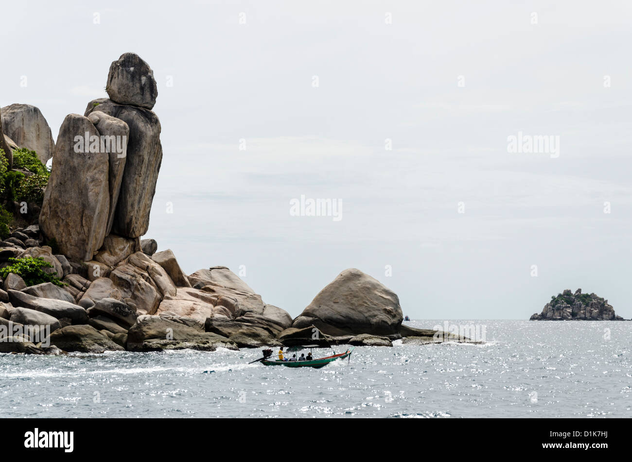 Longtail boat goes by spectacular tall leaning rock formations in ...
