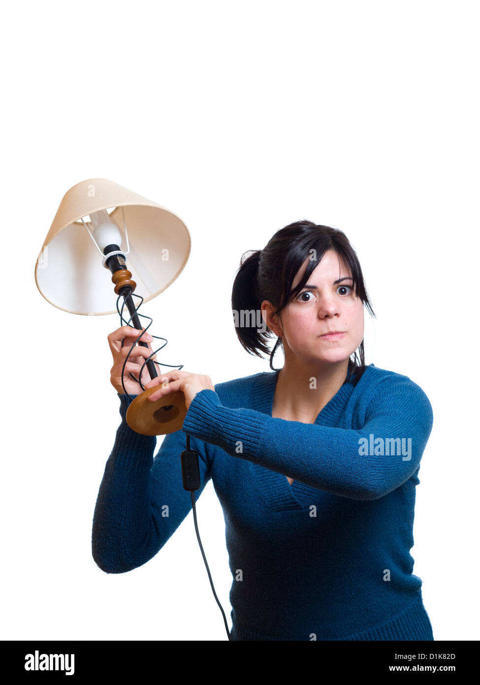 Young woman holding lamp in aggressive manner Stock Photo