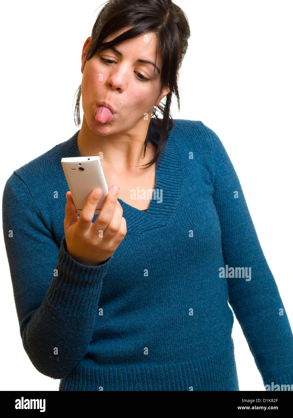 Angry young woman sticking her tongue out at mobile phone Stock Photo