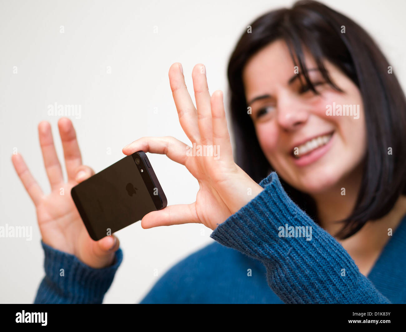 Young woman taking photos with iPhone 5 smartphone Stock Photo