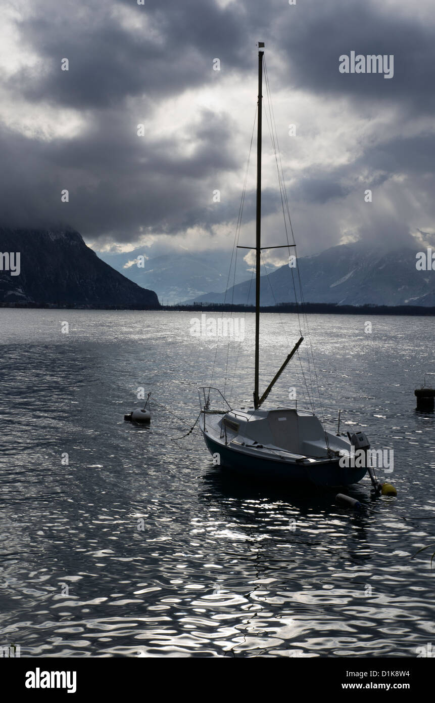 Sailing boat moored on Lake Geneva, with mountains behind. Near Montreux, Switzerland Stock Photo