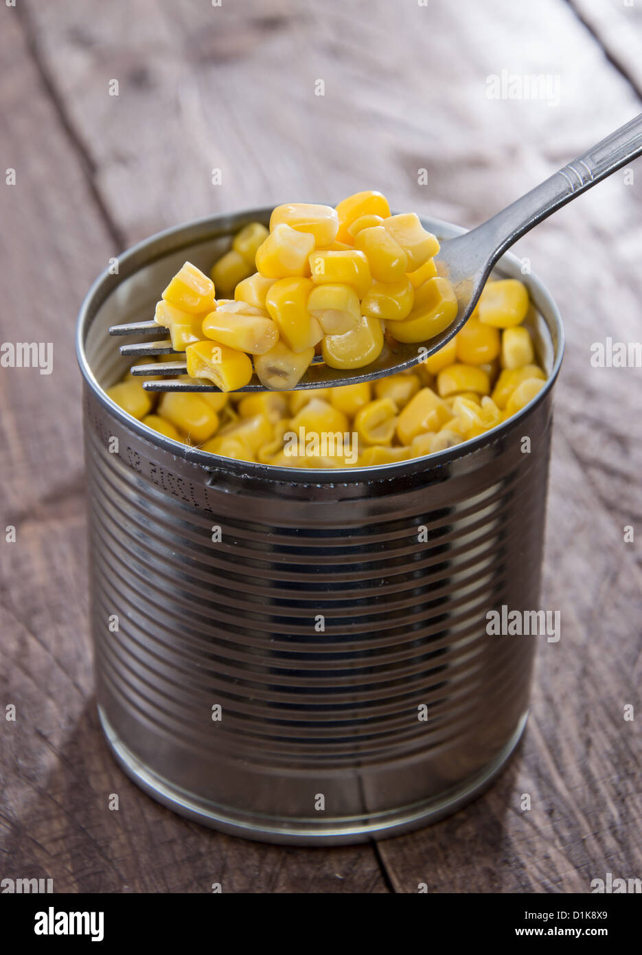 Canned Corn with Fork on wooden background Stock Photo
