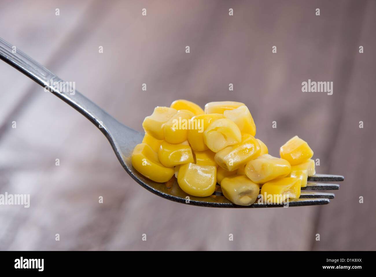Corn on a Fork on wooden background Stock Photo