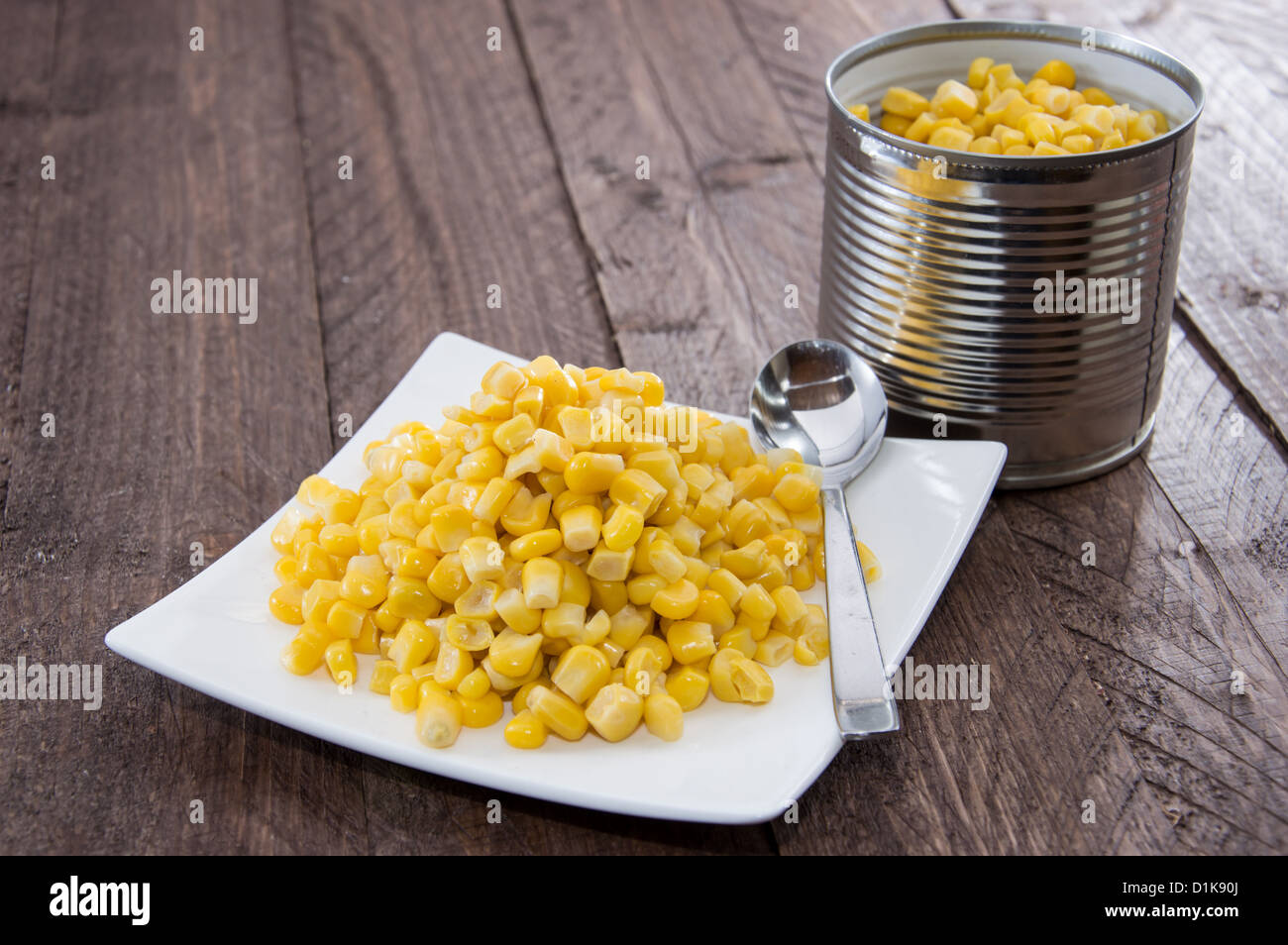Plate with Corn on wooden background Stock Photo