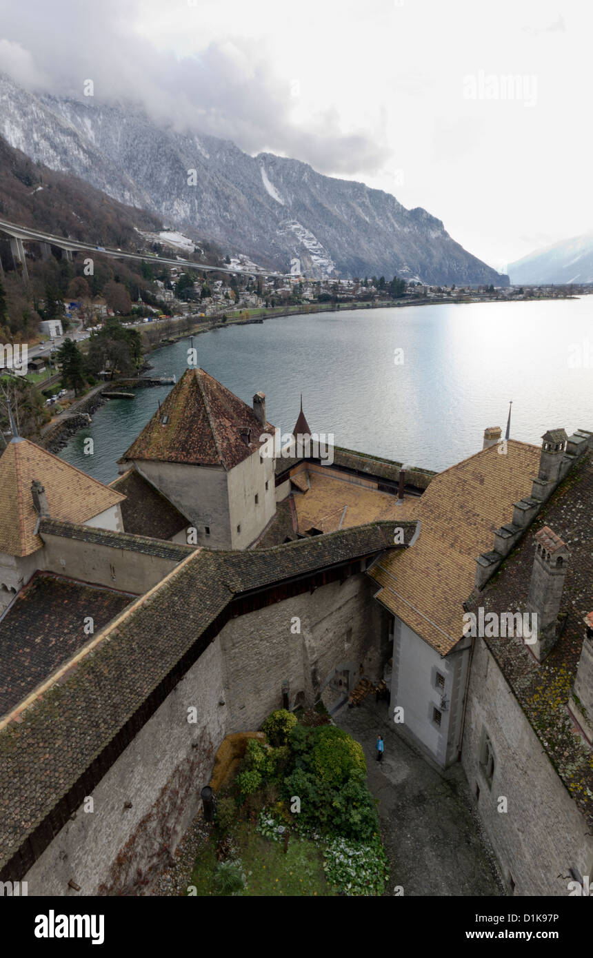 View over Chateau de Chillon (Chillon Castle) on the edge of Lake Geneva, Switzerland with  mountains behind. Stock Photo