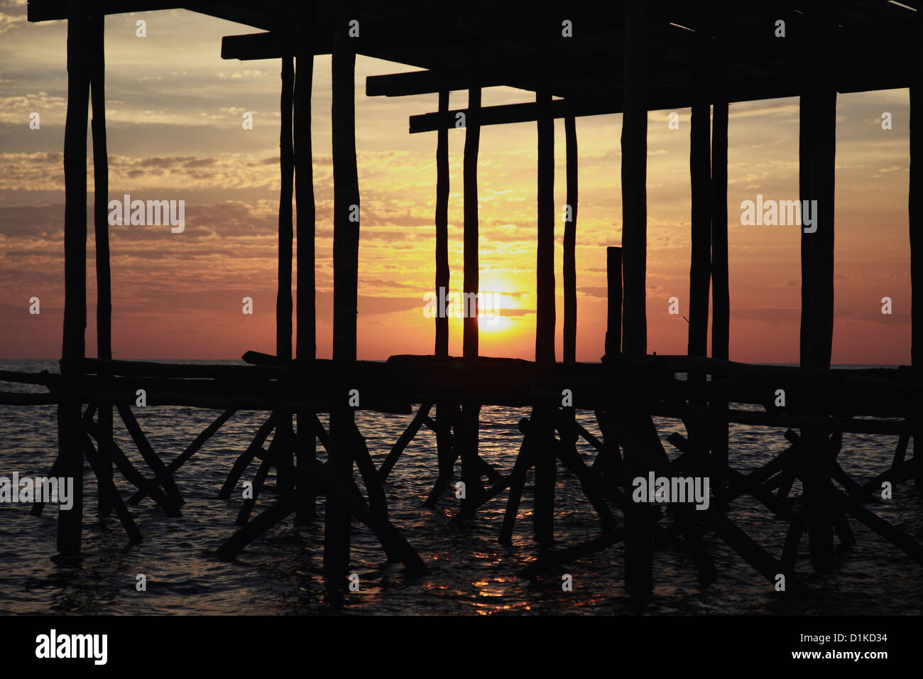 Sunset shining through a wooden pier, Cambodia Stock Photo