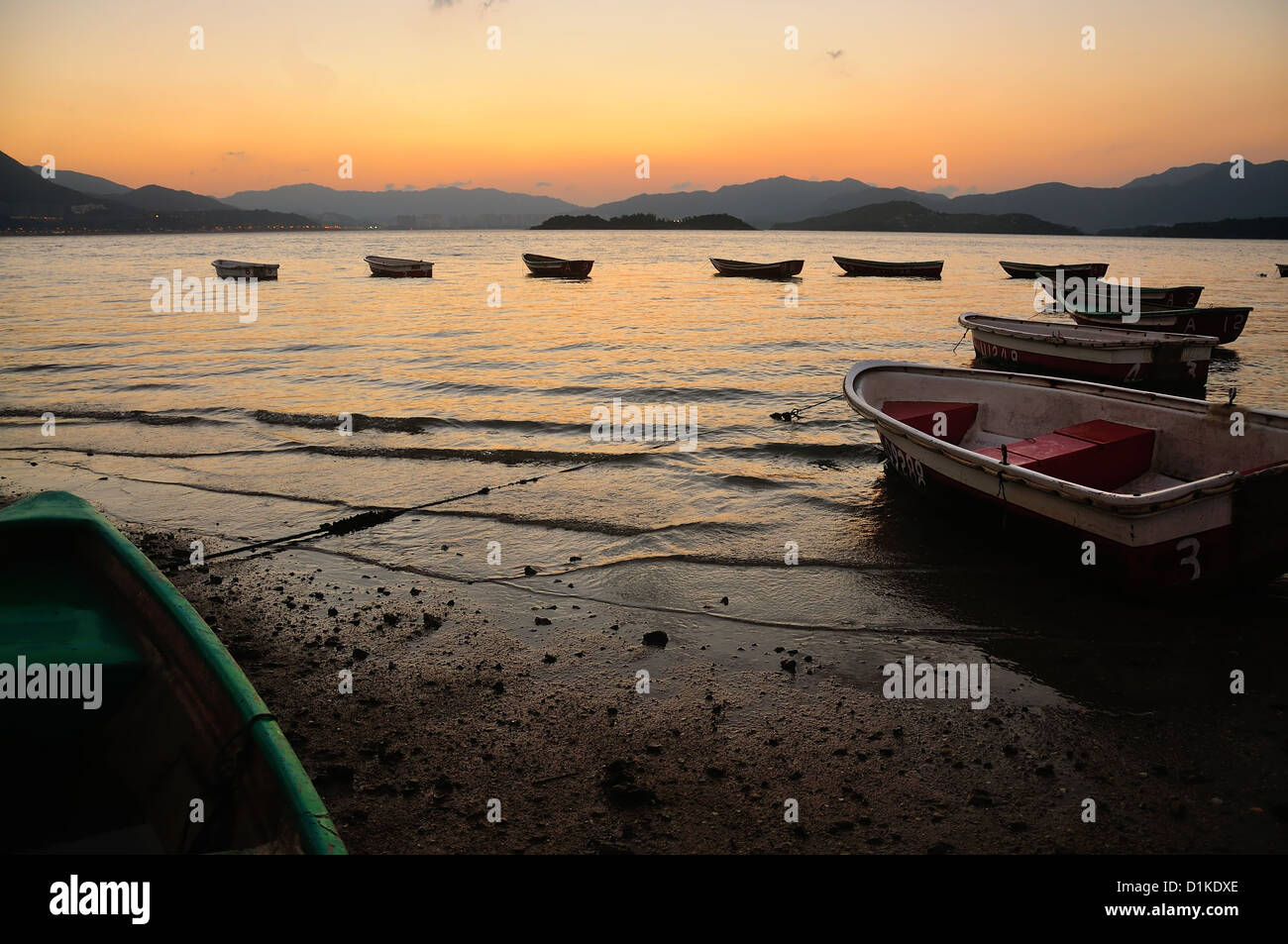 Sunset at beach with boat in the water. In Hong Kong Stock Photo - Alamy