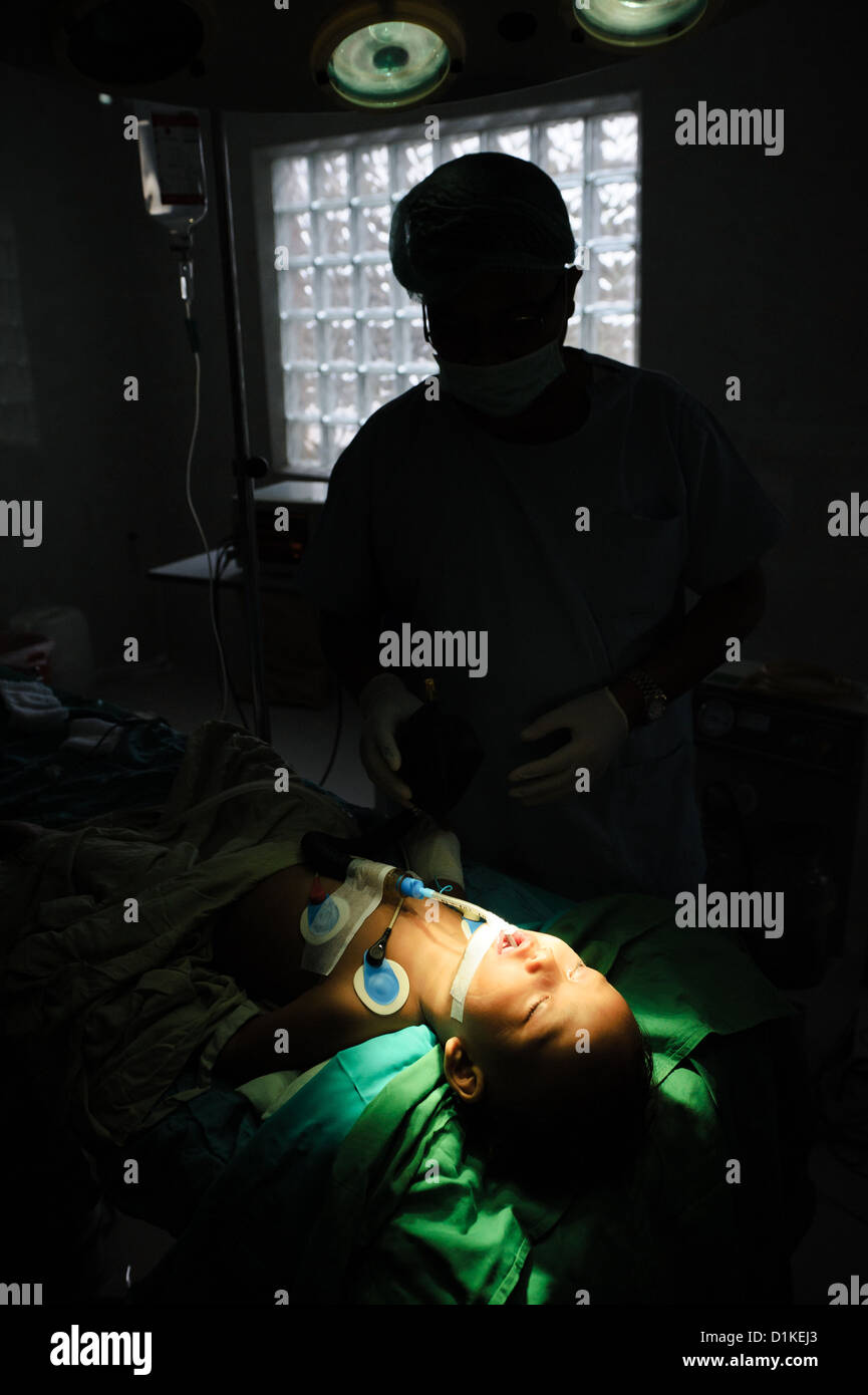 A young child lying in an operating theatre after surgery to repair a cleft in his soft palate, Bali, Indonesia. Stock Photo