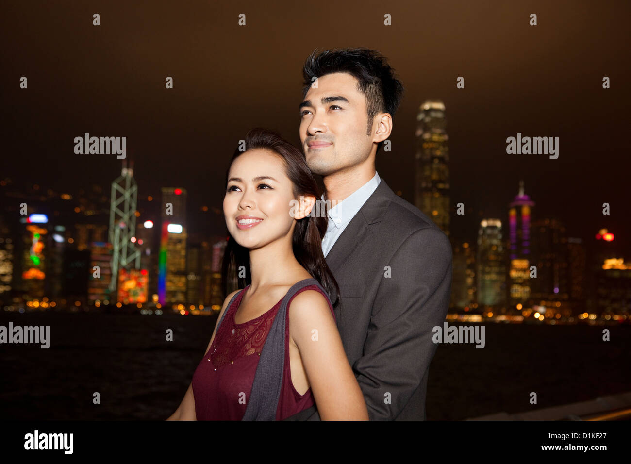 Happy young couple enjoying the night view of Victoria Harbor, Hong ...
