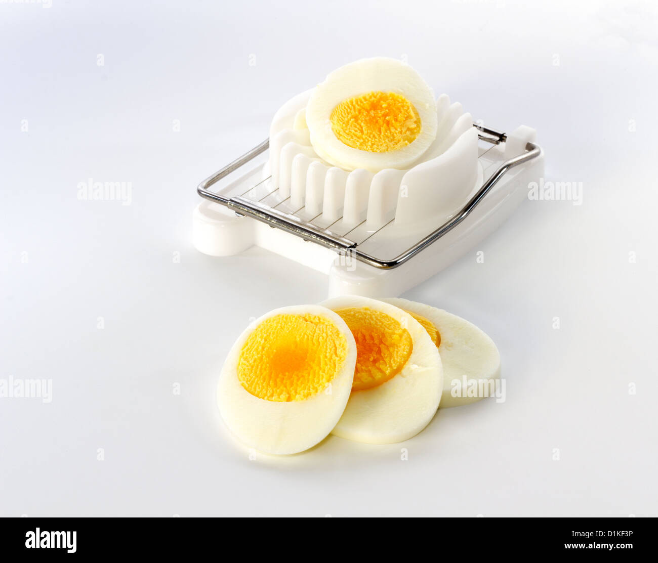 https://c8.alamy.com/comp/D1KF3P/an-white-egg-slicer-with-half-an-egg-and-a-few-slices-in-front-D1KF3P.jpg
