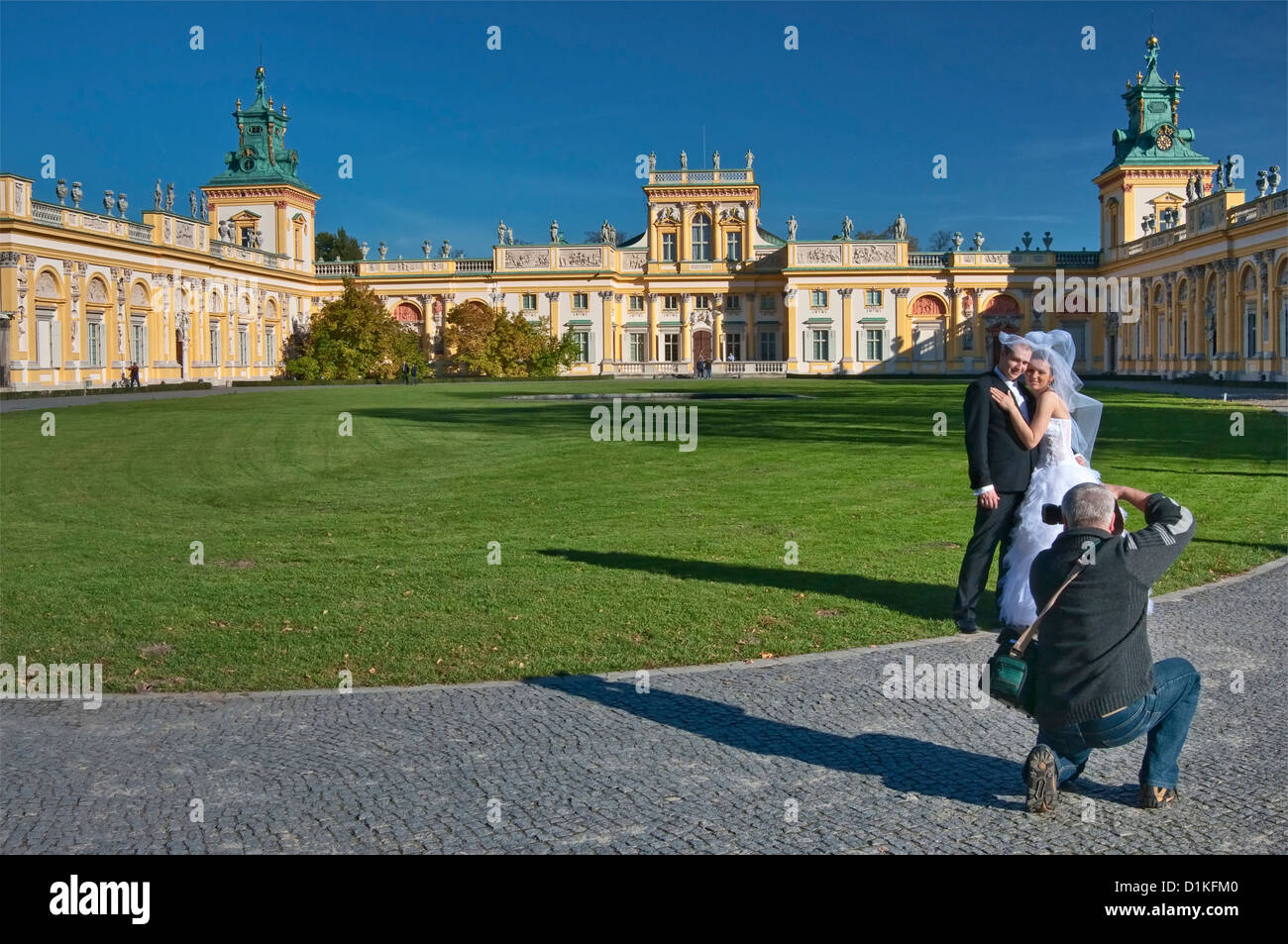 Photographing bride and groom at courtyard of Wilanów Palace in Warsaw, Poland Stock Photo