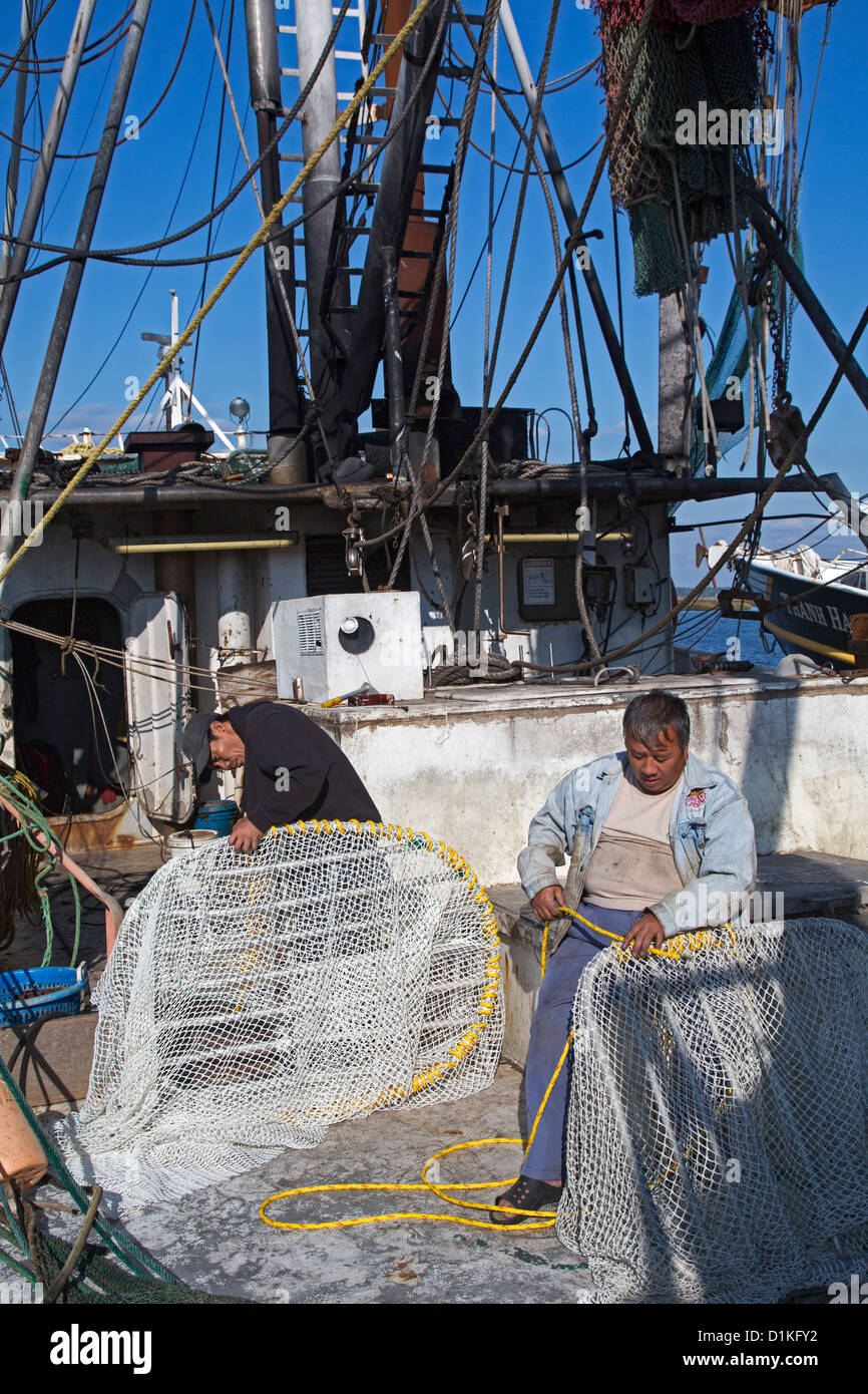 Biloxi, Mississippi Shrimp fishermen work on their nets while docked