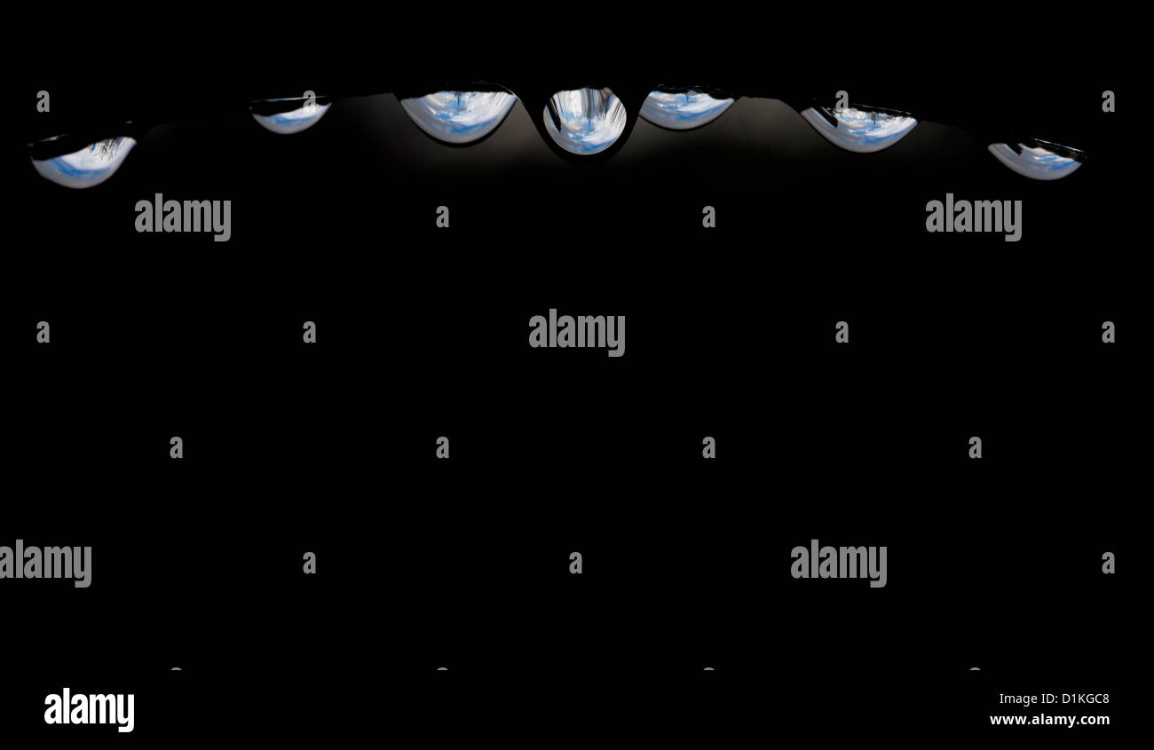 Arc of water drops with reflections and refractions. Stock Photo