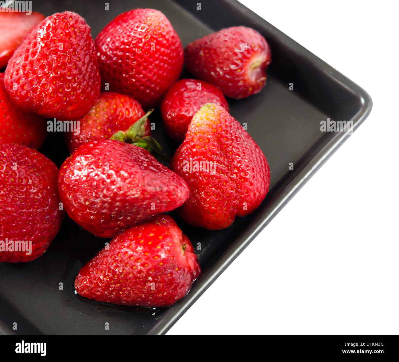 fresh strawberries on black dish over white background Stock Photo - Alamy