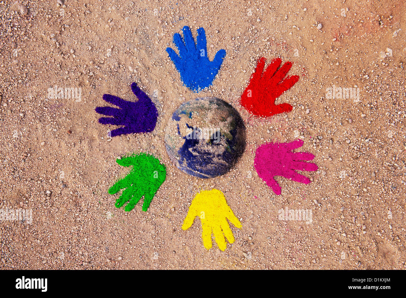 Coloured powder hand prints in a circular pattern on a dirt track with the earth composited in the middle Stock Photo
