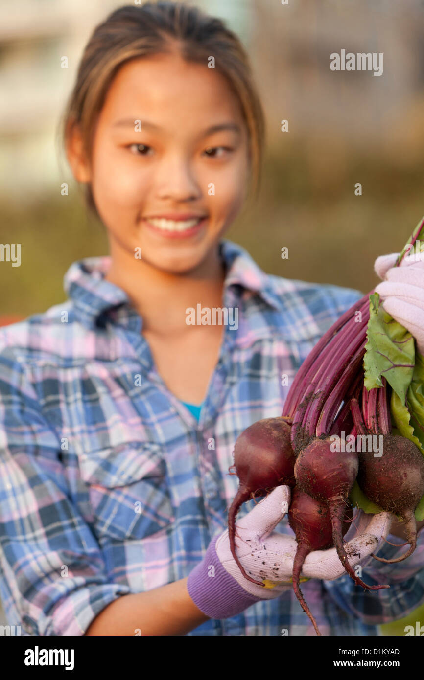Japanese girl holding bunch of beets Stock Photo