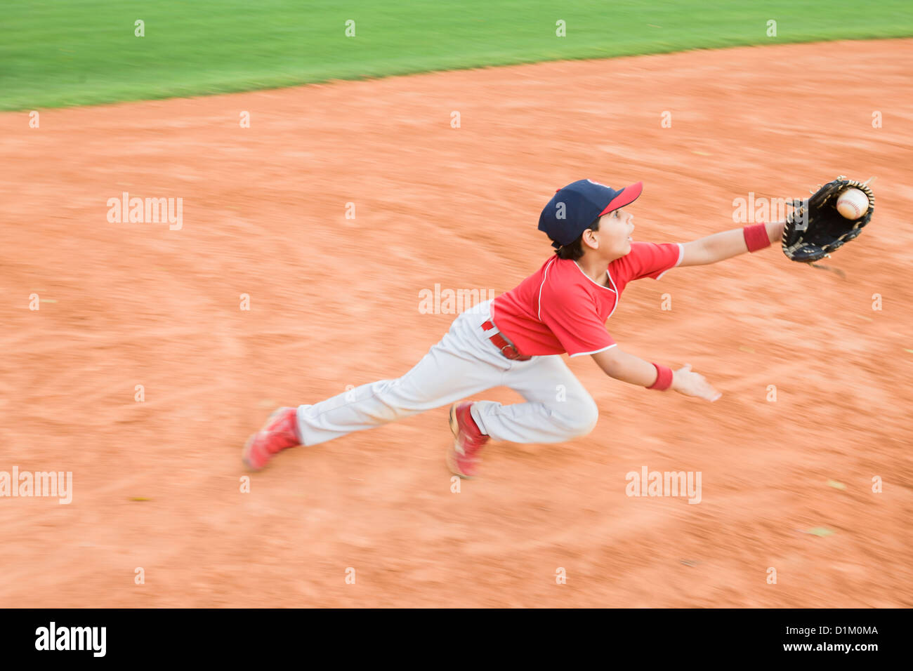 Hispanic baseball player catching ball Stock Photo