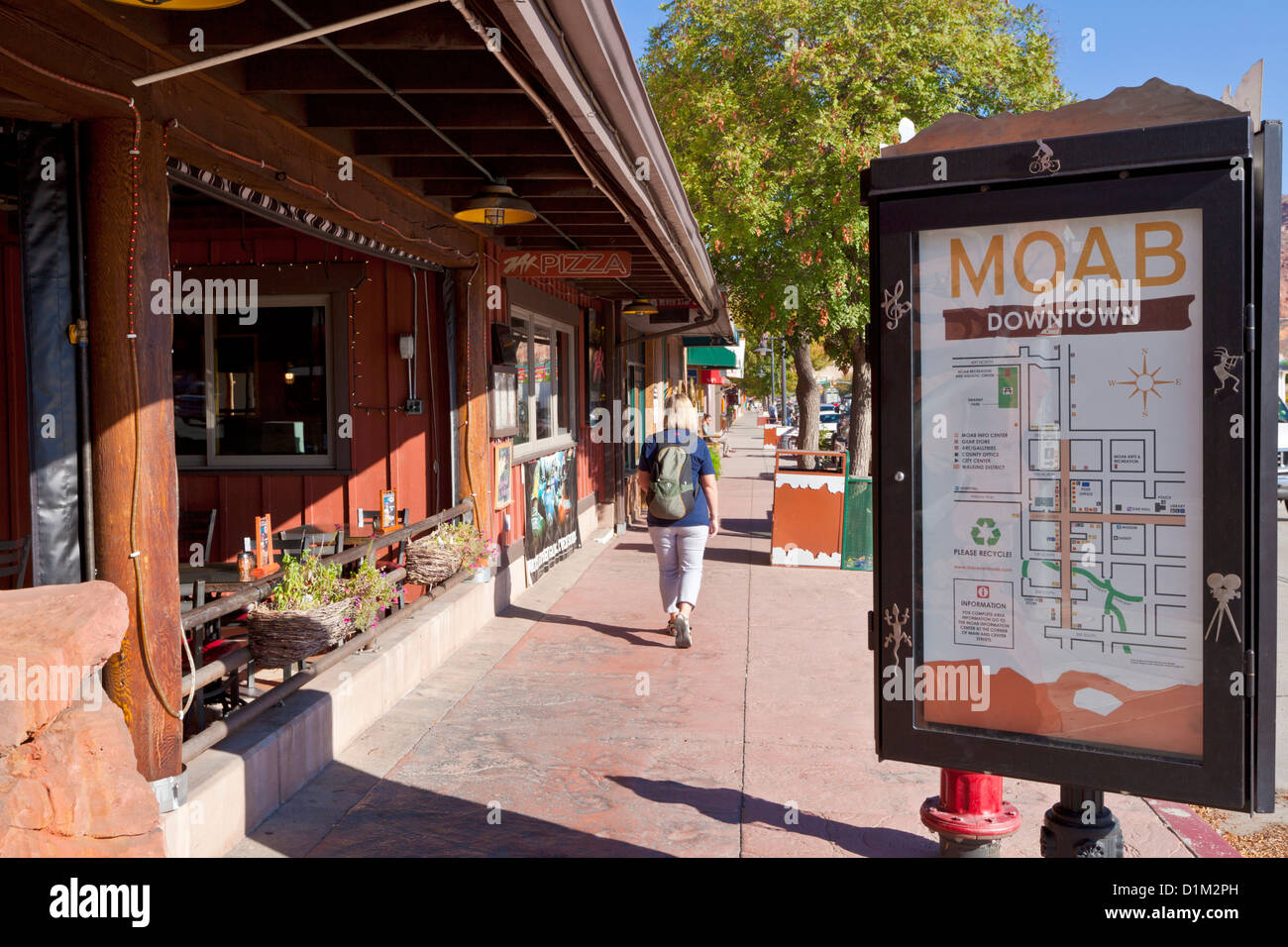 Woman walking along the main street and Shops in Downtown Moab main street Moab Utah United States of America USA US Stock Photo