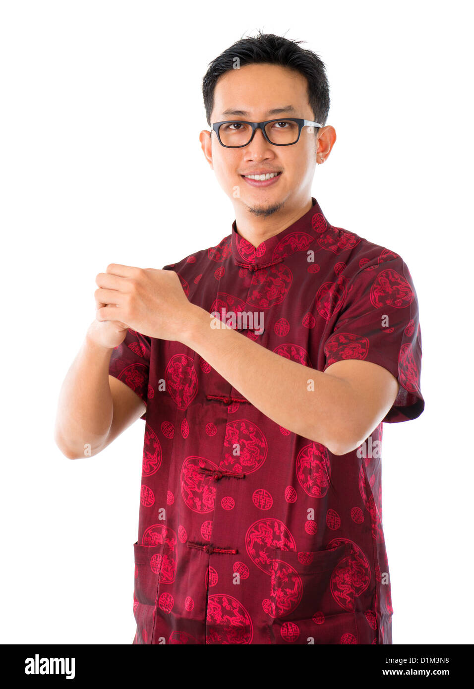 Southeast Asian Chinese man in traditional Chinese Tang suit greeting, isolated on white background Stock Photo