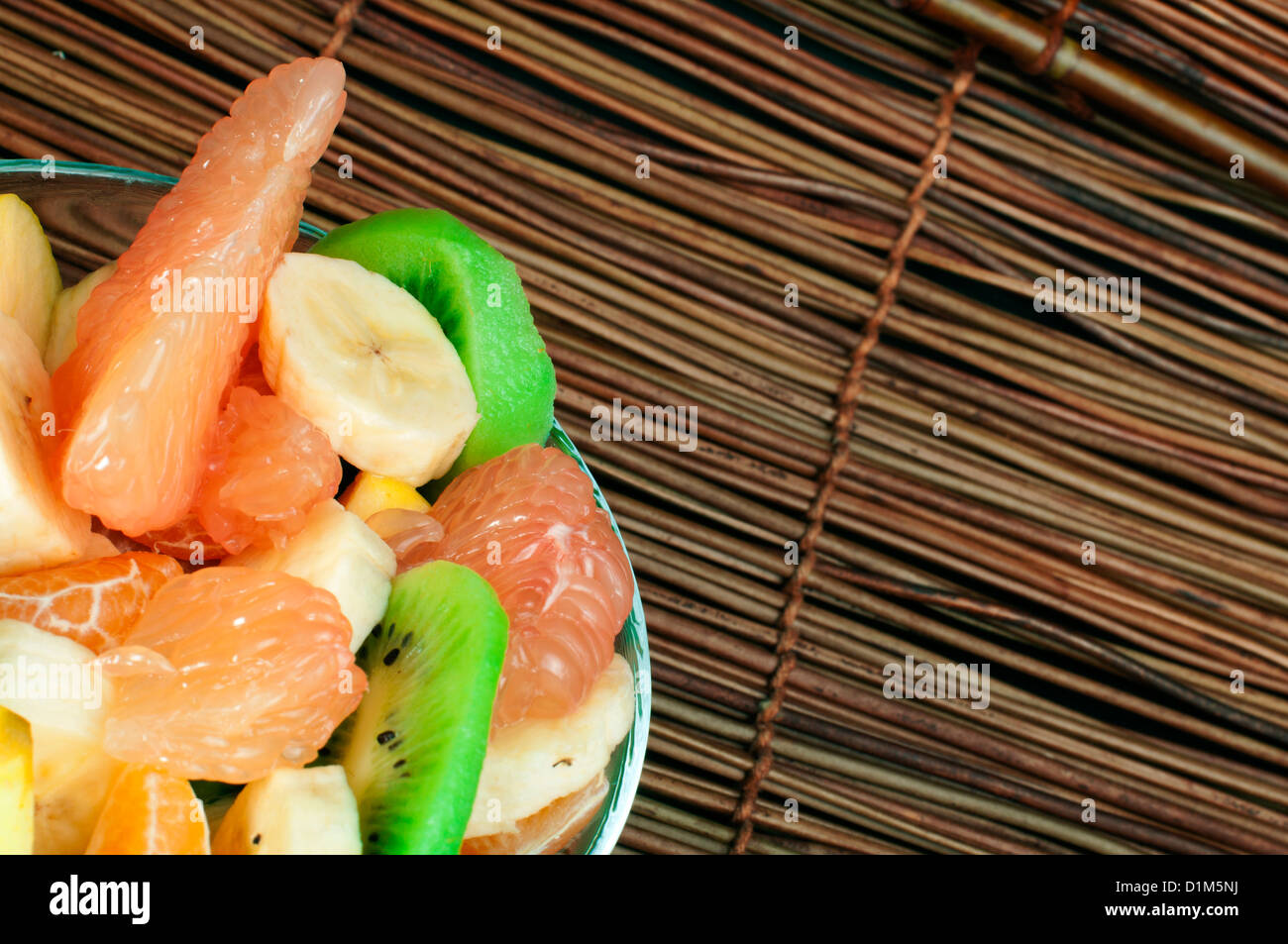 Fruit salad with citrus in a glass bowl on a wooden base Stock Photo ...