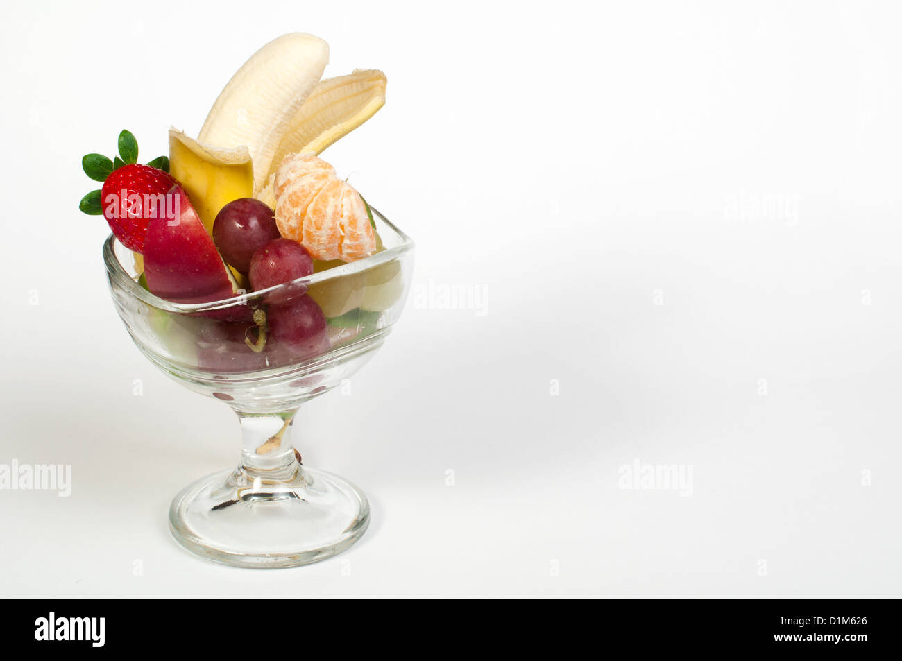 Fruit salad in a glass bowl on white background Stock Photo - Alamy