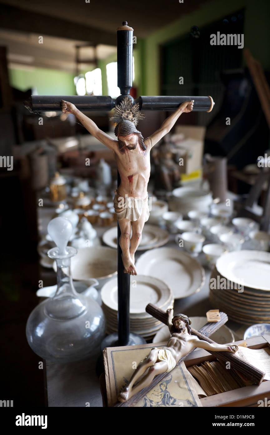 Two statuettes of Jesus on the cross amongst bric-a-brac in a thrift store, illustrating religion being relegated to the past Stock Photo
