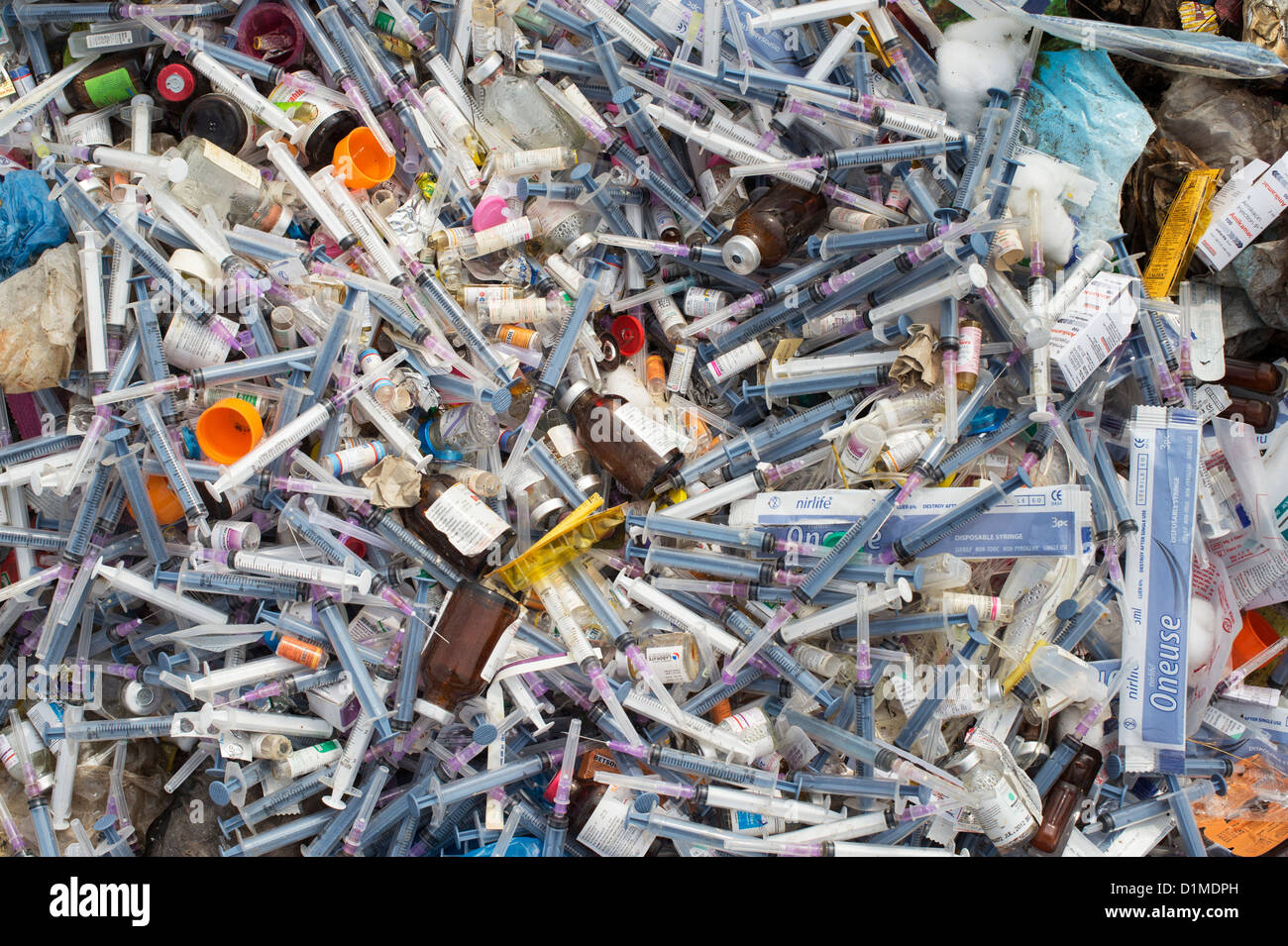 Hypodermic syringes with needles dumped in rubbish in the Indian countryside. Andhra Pradesh, India Stock Photo