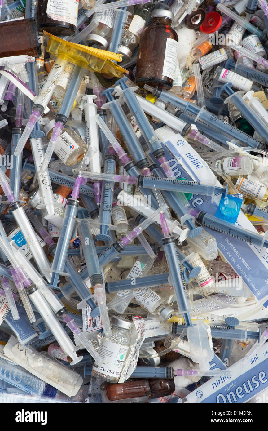 Hypodermic syringes with needles dumped in rubbish in the Indian countryside. Andhra Pradesh, India Stock Photo