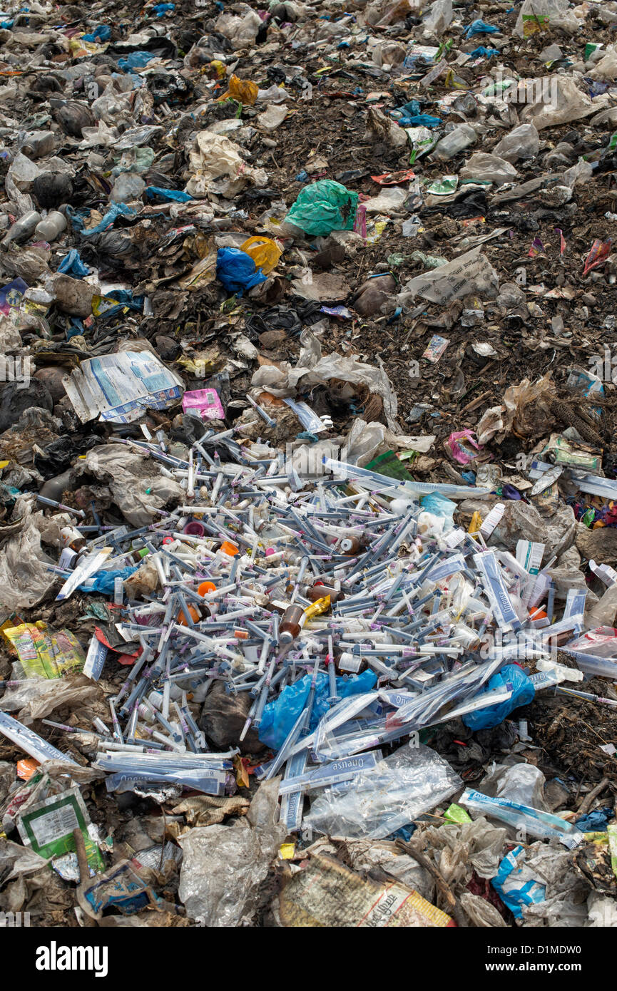 Hypodermic syringes with needles dumped in rubbish in the Indian countryside. Andhra Pradesh, India Stock Photo