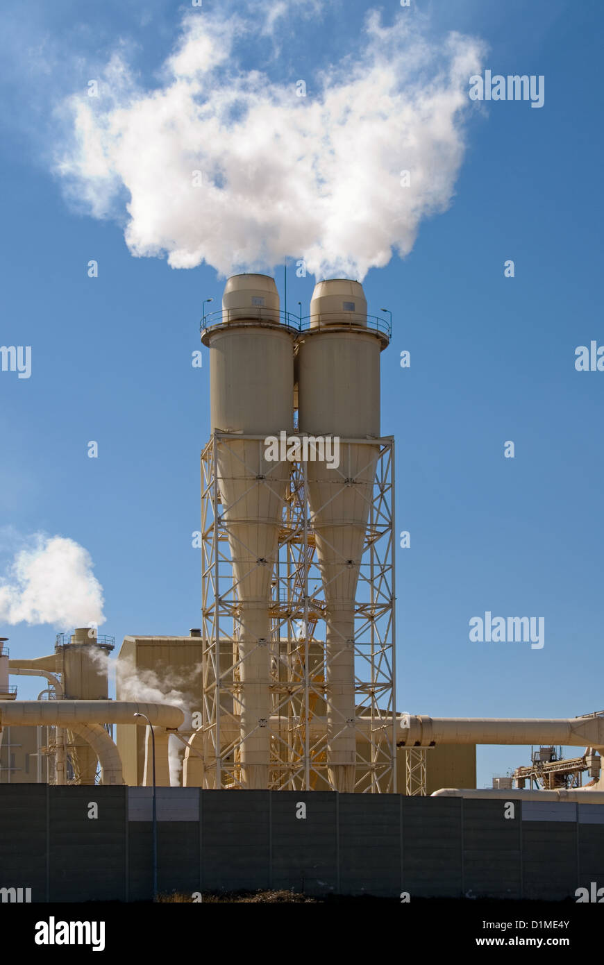 Smoke Stacks belching out steam in a rural paper mill Stock Photo