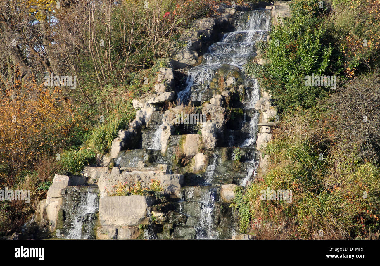 Scenic view of rocky waterfall in autumn forest. Stock Photo