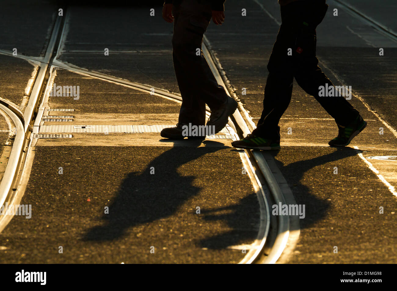 People crossing Railroad Tracks in Back Light in Berlin, Germany Stock Photo