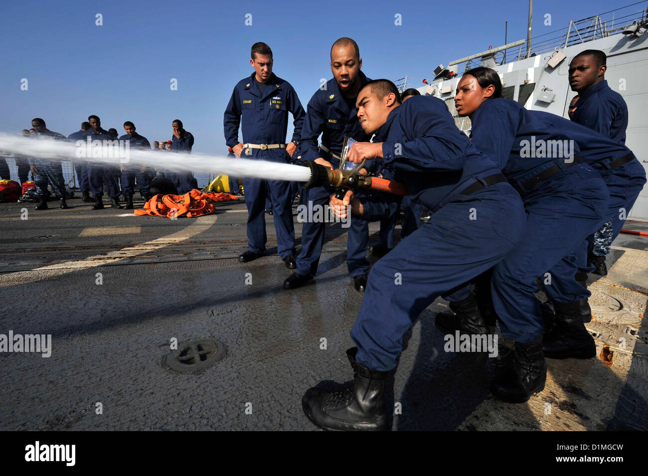 Sailors handle a fire hose during damage control Olympics aboard the guided-missile destroyer USS Jason Dunham (DDG 109). Jason Dunham is deployed to the U.S. 5th Fleet area of responsibility conducting maritime security operations, theater security cooperation efforts and support missions for Operation Enduring Freedom..ARABIAN SEA (Dec.29, 2012) US Navy Photo Stock Photo
