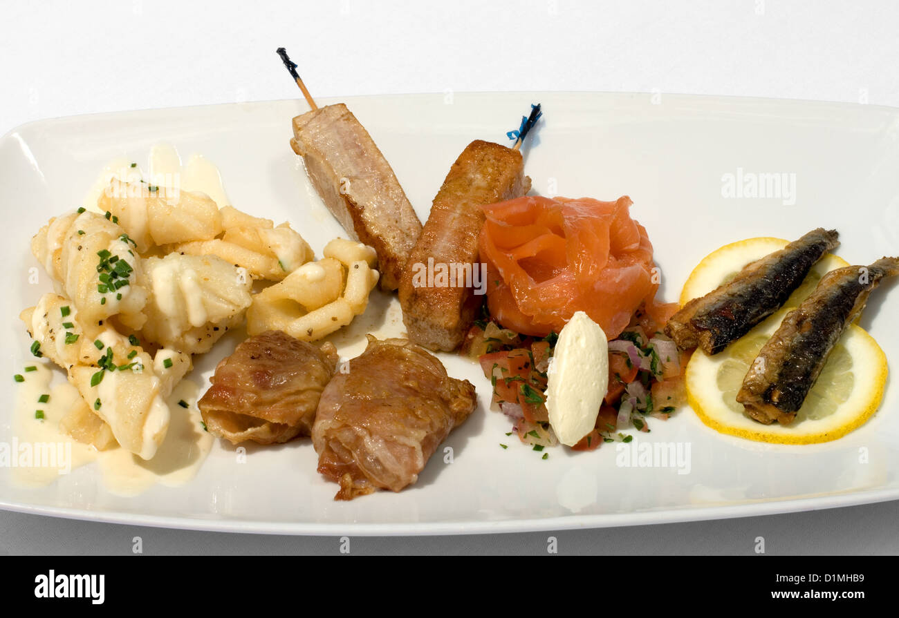 An Entree of Salt & Pepper Squid with Aioli, Tuna skewers,  Sardines, Porsciutto-wrapped Scallops, and smoked Atlantic Salmon Stock Photo