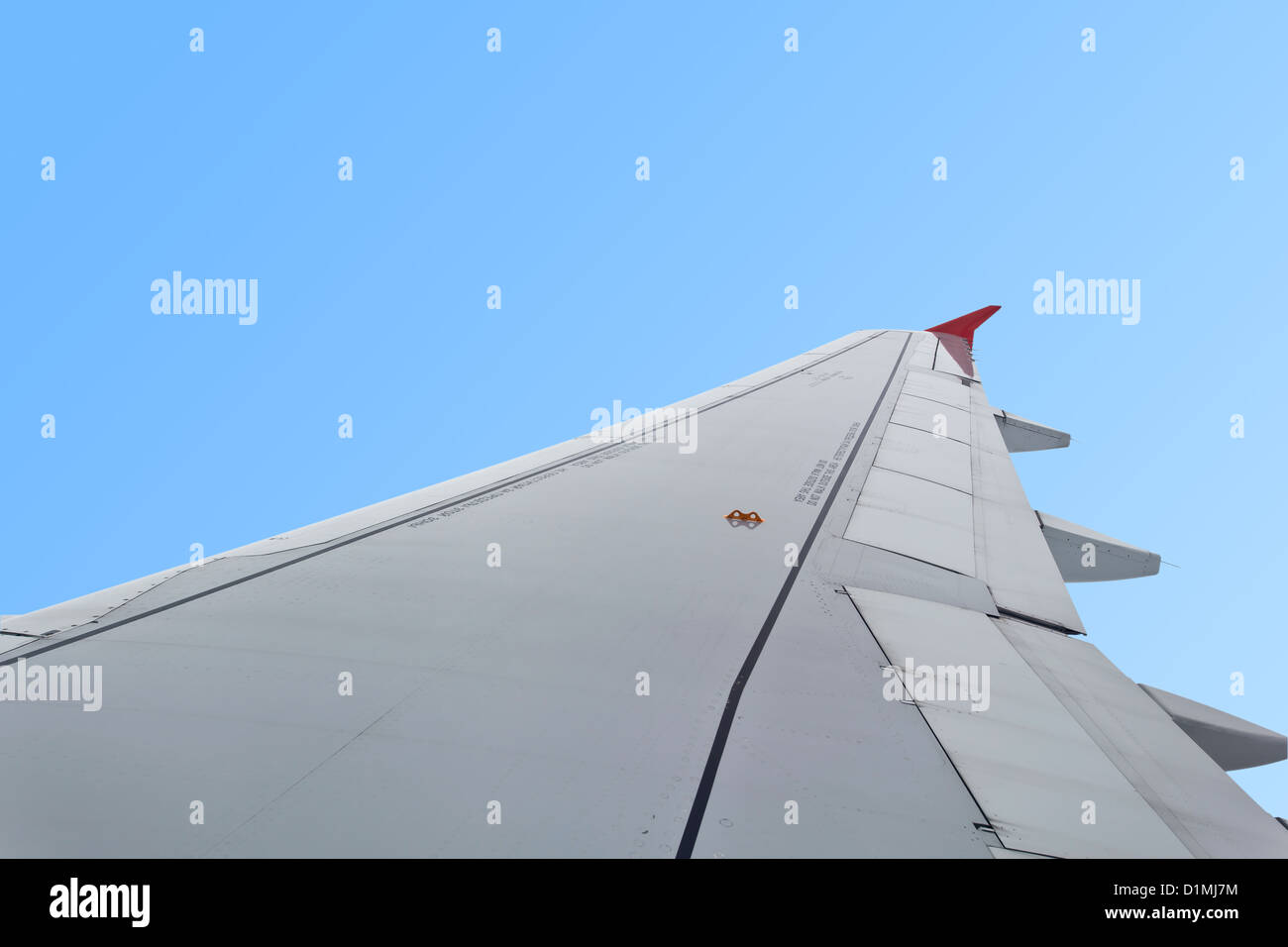 Wing of an airplane flying in blue sky Stock Photo - Alamy