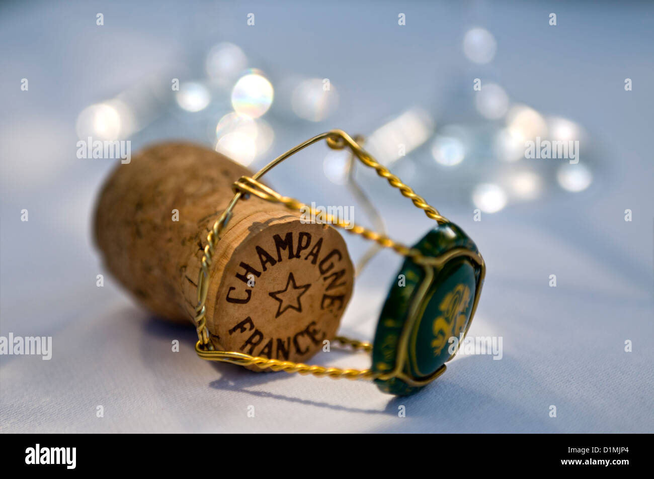 Champagne cork on white tablecloth with wire retaining frame and cap